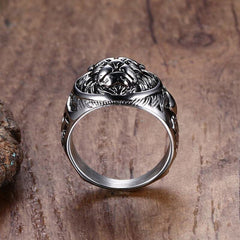 Silver ring with intricate design on a wood grain background