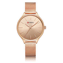 Rose gold watch in rose gold with a mesh band on a white background
