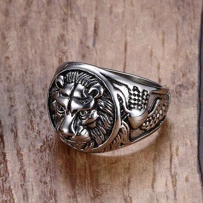 Silver ring with intricate design on a wood grain background